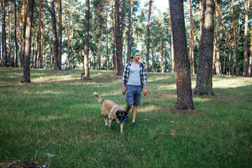 Young man with his old dog in forest.