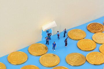 Miniature creative finds gold coins through paper wall