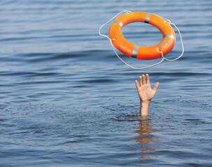 Drowning man with raised hand getting lifebelt in sea, closeup