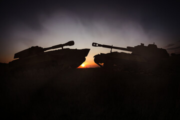 Naklejka premium Silhouettes of tanks on battlefield in night