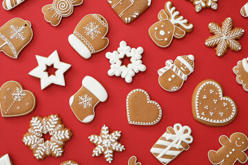 Different Christmas gingerbread cookies on red background, flat lay