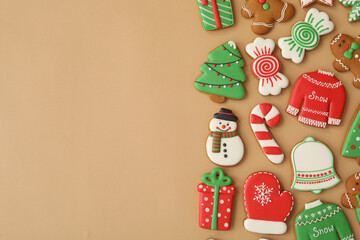 Different Christmas gingerbread cookies on brown background, flat lay. Space for text
