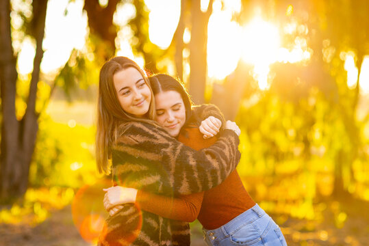 teenage girl comforting her friend with a hug