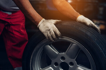 Mechanic holding a tire at the repair garage. Repair service.