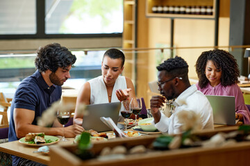 The businesspeople sit in a restaurant and have a business meeting during dinner.