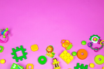 Flat lay plastic and wooden kids toys on pink background. Frame background with blank space, copy space, space for text