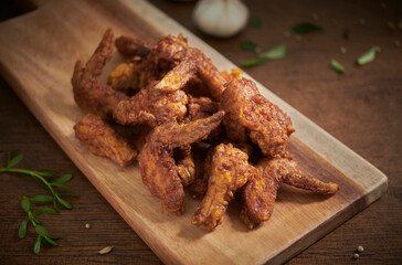 Spicy Deep Fried Breaded Chicken Wings and drumsticks. Fresh fried chicken on a wood table. Selective focus.