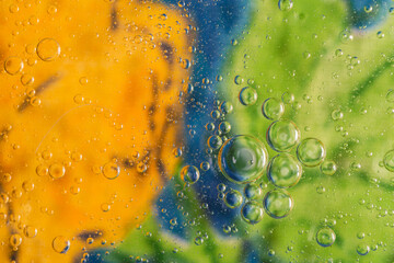 macro of olive oil drops on water as abstract background