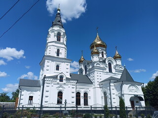 Fototapeta premium A panorama of the beauty and grandeur of the Orthodox Cathedral in the rays of the morning sun against the background of a blue, barely cloudy sky.