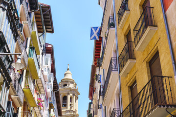 Aged church and houses on urban alley in Spain