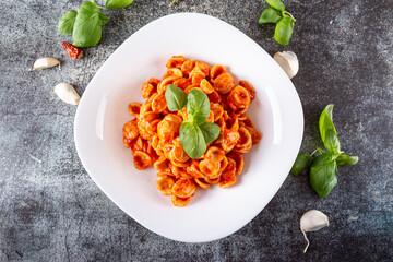 Orecchiette with fresh tomato sauce and basil. Typical dish of Italian Cuisine. Vegetarian food, quick lunch.