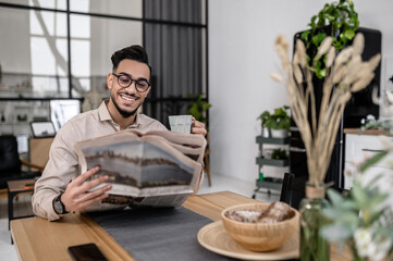 Man sitting with coffee reading newspaper