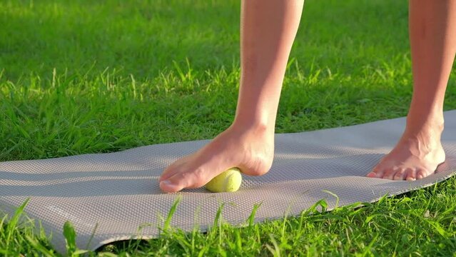 Myofascial release, Foot fascia massage with a ball, fitness, self-care, health, smart fitness. Myofascial relaxation of foot muscles with a massage ball on a mat at home, close-up