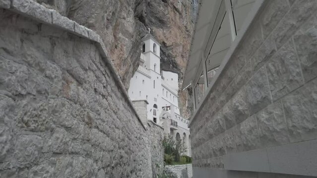 Ostrog monastery in Montenegro seen from a rock cliff crevice. The unique monastery in the rock. the Monastery of Ostrog dedicated to Saint Basil of Ostrog. 4K videos.