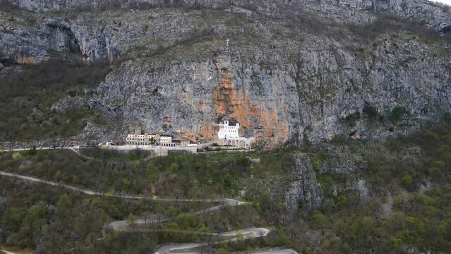 Aerial drone view of Ostrog monastery in vertical rocky mountain is the most popular pilgrimage place in Montenegro. The unique monastery in the rock