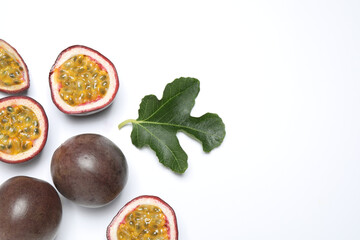 Fresh ripe passion fruits (maracuyas) with leaf on white background, flat lay. Space for text