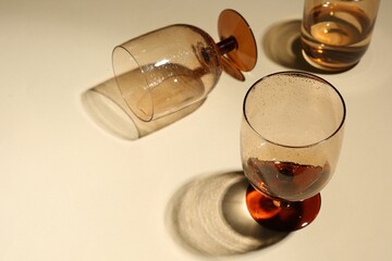 Glasses with drinks on beige background, space for text