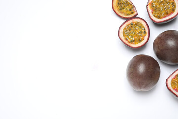 Fresh ripe passion fruits (maracuyas) on white background, flat lay. Space for text