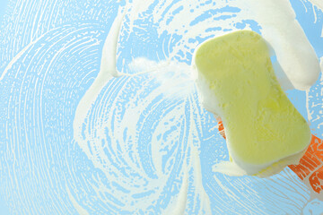 Person cleaning glass with sponge, view from inside