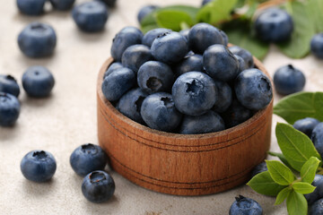 Tasty fresh blueberries on light grey table, closeup