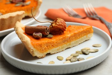 Slice of delicious homemade pumpkin pie on plate, closeup