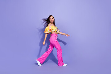 Fototapeta na wymiar Full size profile portrait of stunning lovely girl walking have good mood isolated on purple color background