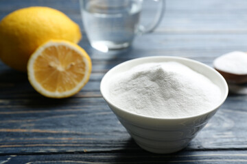 Baking soda in bowl on blue wooden table