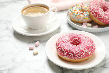 Yummy donut with sprinkles and coffee on white marble table