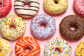 Delicious glazed donuts on pink background, flat lay