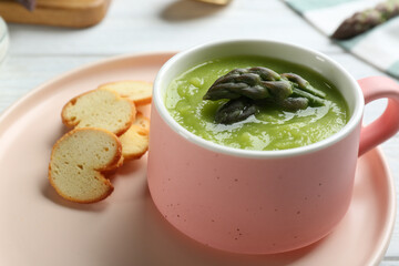 Delicious asparagus soup served on table, closeup