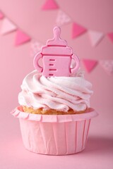 Beautifully decorated baby shower cupcake for girl with cream and topper on pink background