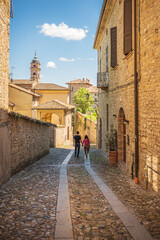 Couple walking a small alley in Castell'Arquato, Piacenza, Italy