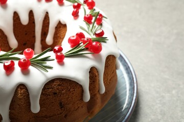 Traditional Christmas cake decorated with glaze, pomegranate seeds, cranberries and rosemary on...