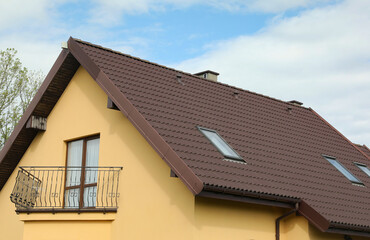 Modern house with brown roof against blue sky