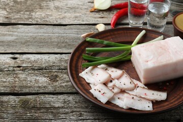 Tasty salt pork with green onion served on wooden table, space for text