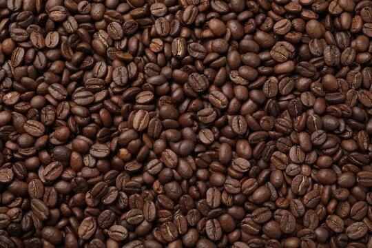 Pile of roasted coffee beans as background, top view
