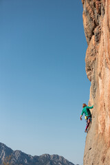 Fototapeta A woman climbs a rock obraz