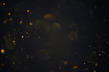 Fototapeta Golden bokeh lights sparkles of glitter dust particles dark abstract overlay background obraz