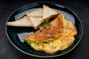 Omelet with vegetables and toast on a plate. Breakfast