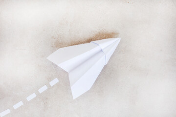 paper airplane as metaphor, taking off and rising, on grey with copy space.