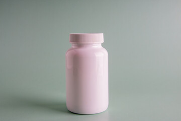 Viral disease prevention concept. Female hand holds jar with vitamins, pills, medicines or drugs on orange background.