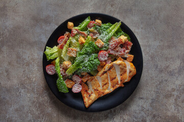 Fried chicken fillet with tomatoes, lettuce, parmesan and croutons