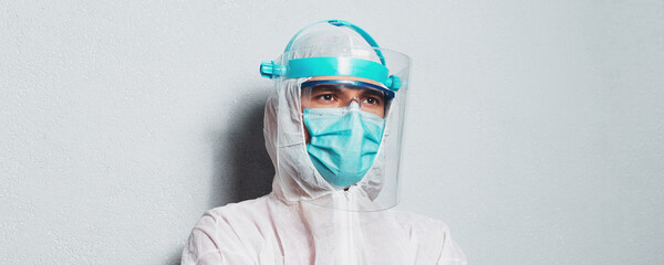 Fototapeta Studio portrait of a doctor in protective suit on white background. Panoramic banner view. obraz