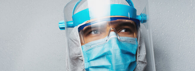 Fototapeta Studio portrait of a doctor in protective suit on grey background. Panoramic banner view. obraz