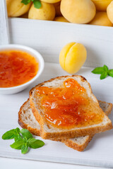 Toasts of bread with apricot jam and fresh fruits with mint