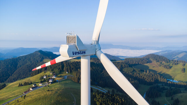 A wind power plant of company Vestas on a mountain ridge on a summer morning