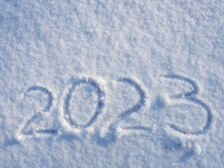 top view on 2023 hand written on the snow. 2022 new year holiday text drawn on snow. 2022 year hand...