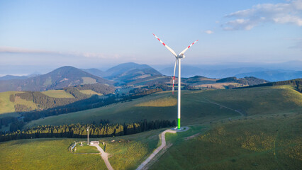 A wind power plant on a mountain ridge on a summer morning