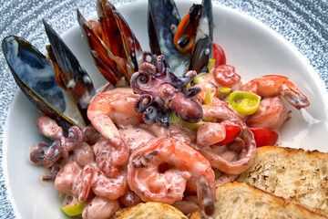Seafood mix with vegetables in cream sauce. Close-up