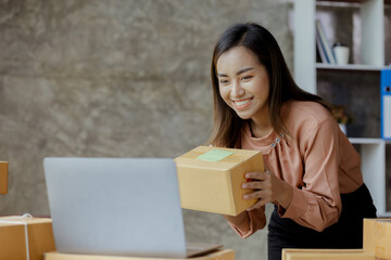 The owner of an online store is checking orders for packaged products in order to prepare them for delivery to customers as ordered through the website. Online selling and online shopping concepts.